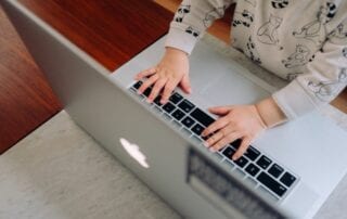 Pornografie für Kinder. Kinderhände und Laptoptastatur