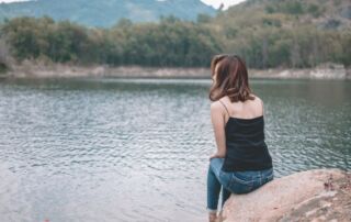 Marys Geschichte. Frau schaut nachdenklich auf einen See.