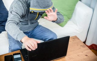 Macht Pornografie süchtig?: Mann vor Laptop versteckt Gesicht hinter seiner Hand