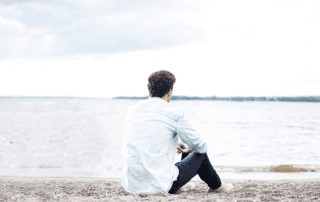 Einsamkeit. Mann sitzt am Strand