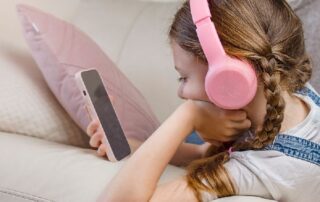 9 Jahren. Mädchen mit Smartphone und Headset